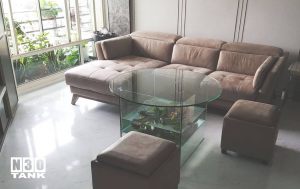 Unique 016: Tempered glass round coffee table with square raise up tank as the table stand. Made from 12mm all clear glass. Size 600mm (L) x 600mm (W) x 600mm (H). Diameter 1000mm Table Top x 12mm clear tempered glass with CNC.